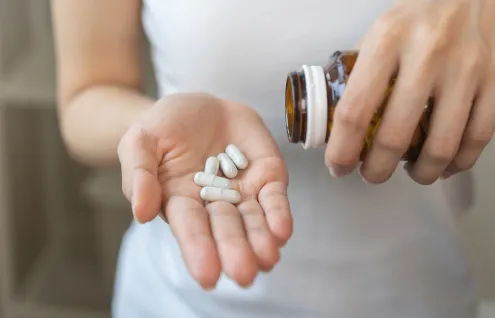 Person pouring medication into the palm of their hand